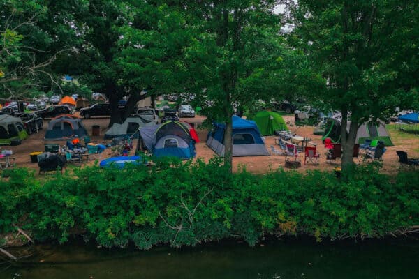 several camp sites and tents setup at sundown near Elk River at River Ranch Resort in Noel, Missouri