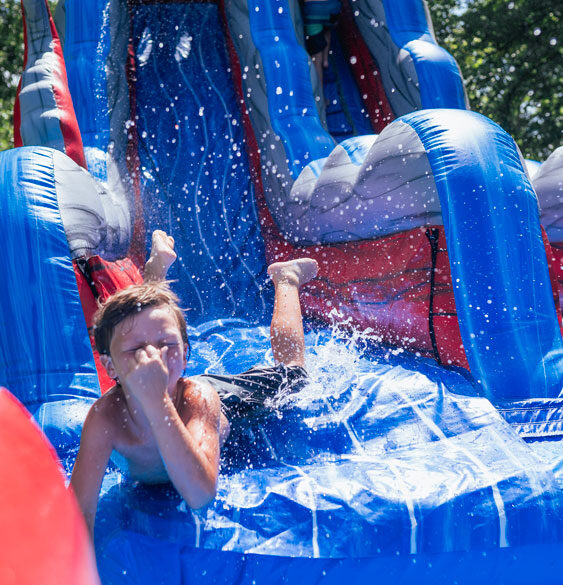 young boy holds his nose as he goes down slide into water River Ranch Resort Noel, Missouri