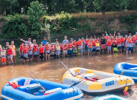 summer camp kids stand in the Elk River to pose for a photo River Ranch Resort Noel, Missouri