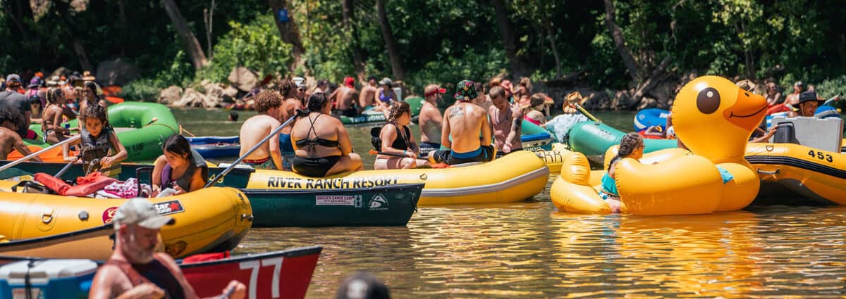 large group of rafters of all ages float on the Elk River with one woman in a oversized rubber duck float River Ranch Resort Noel, Missouri