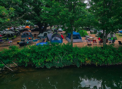 view of several tents set up along the Elk river at River Ranch Resort in Noel, Missouri