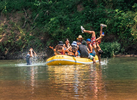 guests on Elk River at River Ranch Resort Noel, Missouri have fun while one guest does a back flip off the raft