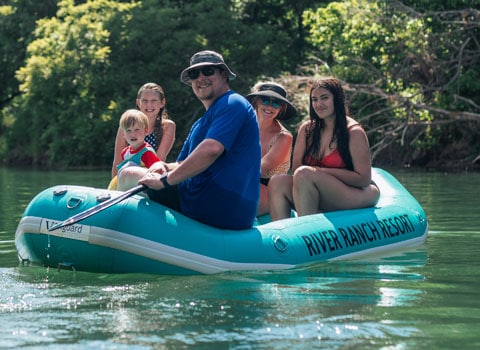 group of five in a teal color raft pose for a photo River Ranch Resort Noel, Missouri