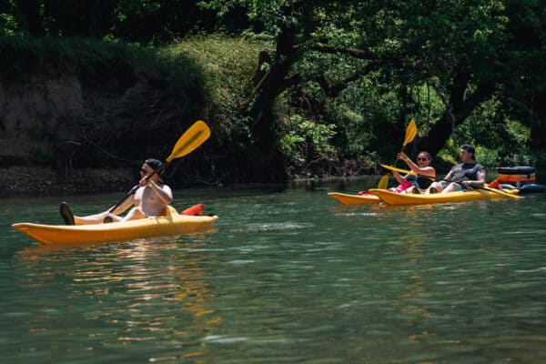 three people kayak on the Elk River with River Ranch Resort in Noel, Missouri