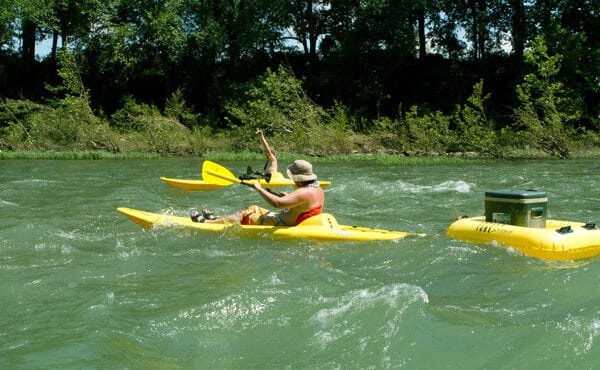 man floating in kayak as cooler raft behind him River Ranch Resort Noel, Missouri