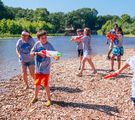 several children play water games along the Elk River during their day camp at River Ranch Resort Noel, Missouri